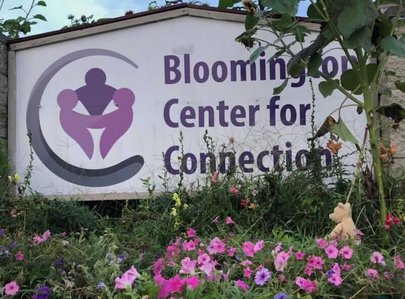 Picture of stuffed winnie bear sitting in front of the BCC sign